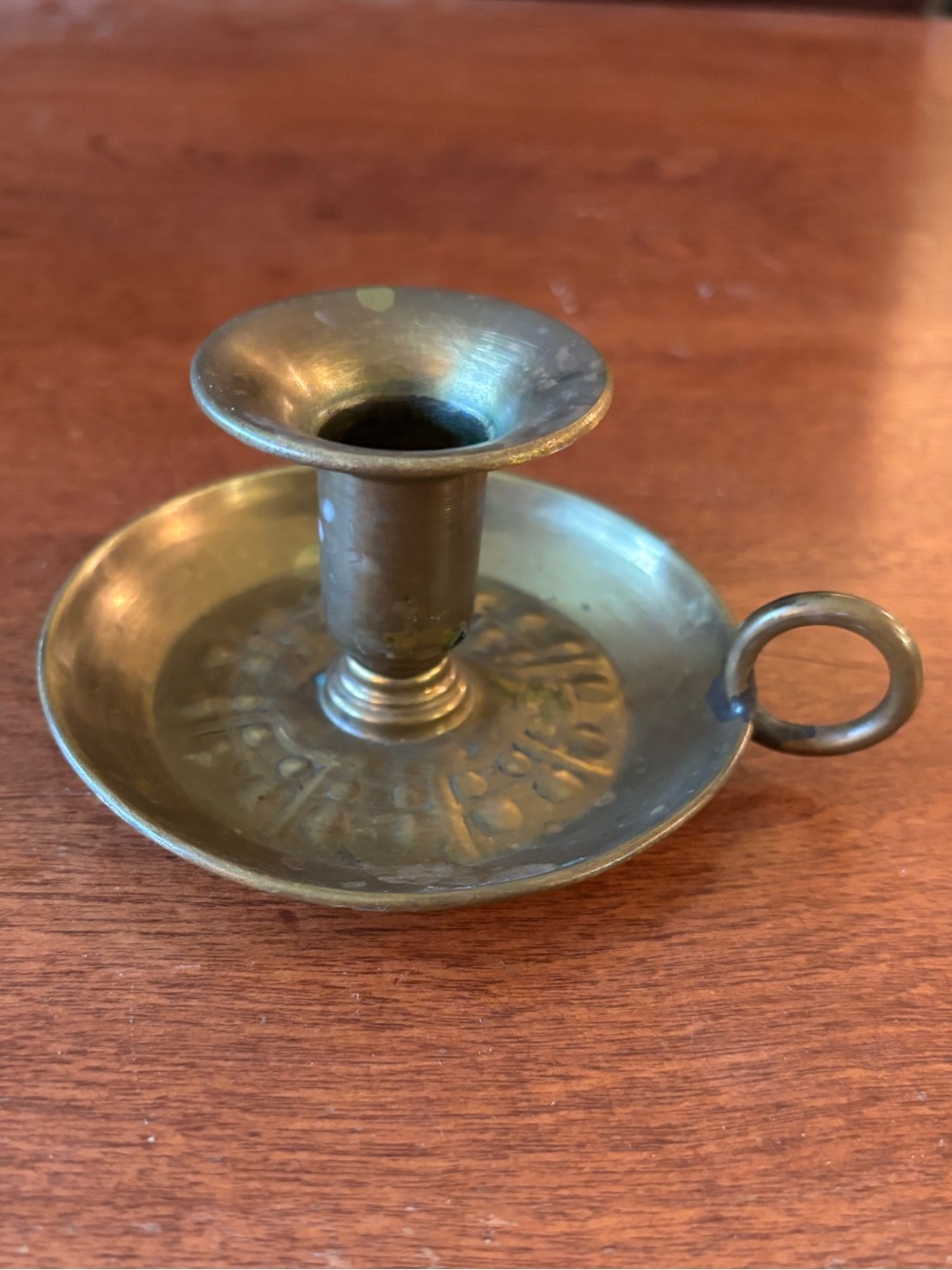 vintage brass chamberstick candle holder with a circular base and a ring handle
